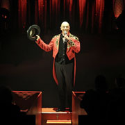 Wolf Fisher im roten Ringmaster-Outfit moderiert souverän eine große Circusproduktion. Mit Charisma, Präsenz und Ausstrahlung erreicht er das Publikum im großen Zeltpalast.